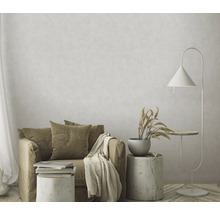 Woonkamer met fauteuil, bijzettafel, staande lamp en decoratie