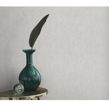 Decoratief behang met een groene vaas, een blad en een bol op een tafel