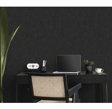 Werkplek met bureau, stoel, laptop en decoratie voor een donkere muur