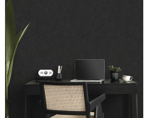 Werkplek met bureau, stoel, laptop en decoratie voor een donkere muur