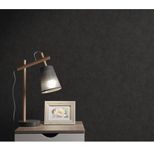 Nachtkastje met lamp en fotolijst voor een donkere muur