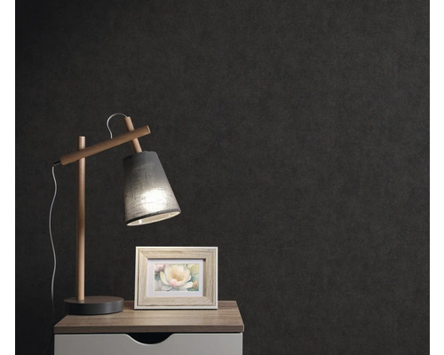 Nachtkastje met lamp en fotolijst voor een donkere muur