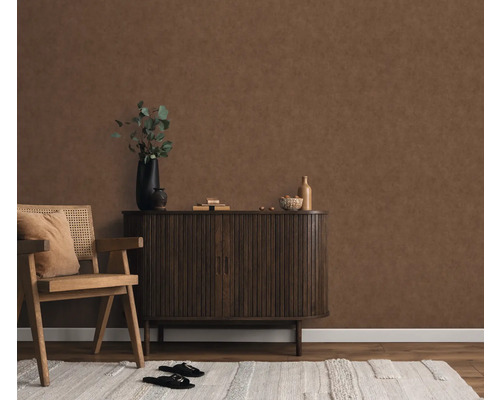 Woonkamer met bruin wandbehang, houten stoel, kast en tapijt voor een gezellige sfeer