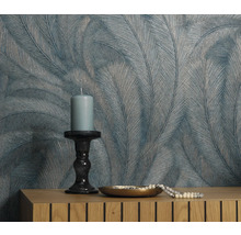 Decoratieve muur met verenbehang, kaars en sieraden op dressoir