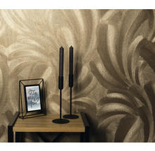 Close-up van een muur met verenbehangmotief, een kandelaar en een fotolijst op een houten tafel