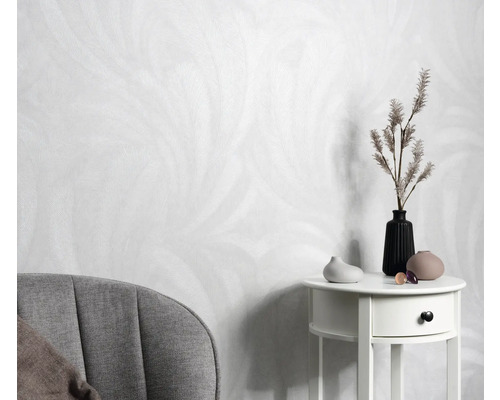 Licht behang met verenontwerp, bijzettafel met vazen en decoratie, fauteuil in de kamer