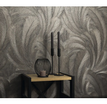 Behang met verenmotief op een tafel met kaarsen en kandelaars