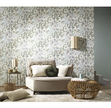 Woonkamer met bloemenbehang, fauteuil en bijzettafels