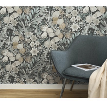 Close-up van een bloemenbehang achter een fauteuil in een kamer