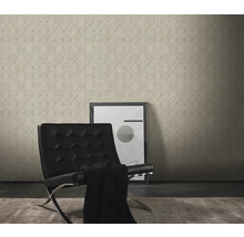 Woonkamer met patroonbehang, fauteuil en schilderij