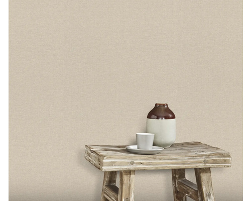 Wand met textielbehang, waarop een kruk met vaas en kopje