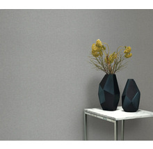 Behang met structuur, geometrische vazen en bloemdecoratie op een tafel