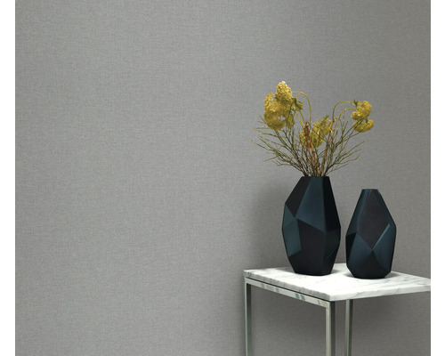 Behang met structuur, geometrische vazen en bloemdecoratie op een tafel