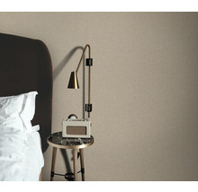 Slaapkameropstelling met textielbehang, nachtkastje en lamp