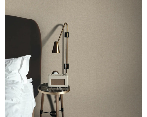 Slaapkameropstelling met textielbehang, nachtkastje en lamp