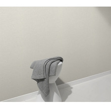 Een grijze sprei ligt op een witte kruk