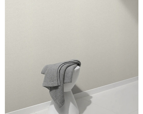 Een grijze sprei ligt op een witte kruk