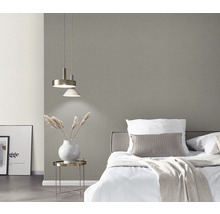 Slaapkamer met bed, nachtkastje, lamp en grijs behang