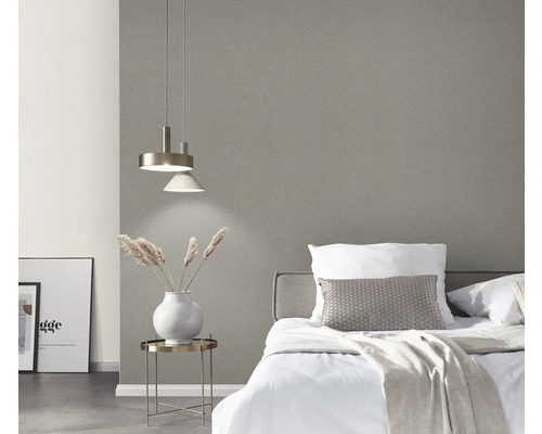 Slaapkamer met bed, nachtkastje, lamp en grijs behang