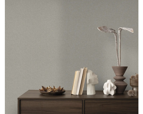 Close-up van een grijs structuurbehang boven een dressoir met decoratieve objecten.