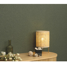 Close-up van een groen textielbehang met tafellamp en decoratie