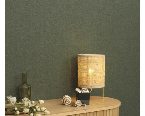 Close-up van een groen textielbehang met tafellamp en decoratie