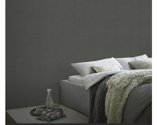 Slaapkamer met textielbehang, bed en nachtkastje