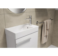 Wastafel met kraan, handdoek en handdoekhouder in een badkamer