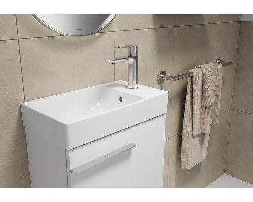 Wastafel met kraan, handdoek en handdoekhouder in een badkamer