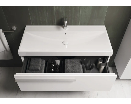 Wastafelonderkast met open lade, handdoeken en badkamerartikelen