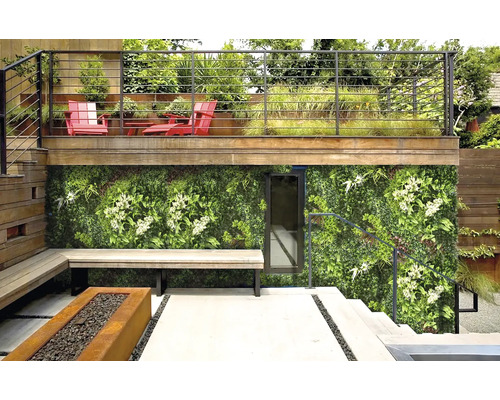 Buitenruimte met groene wand, zitbank en vuurplaats