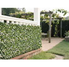 Decoratieve groene bladerenmat als privacyscherm in de tuin.