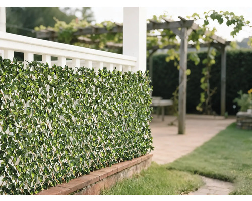 Decoratieve groene bladerenmat als privacyscherm in de tuin.