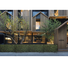 Gevel van een modern gebouw met houten bekleding en begroeiing