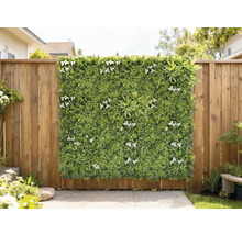 Decoratief groen paneel met witte bloemen tegen een houten schutting