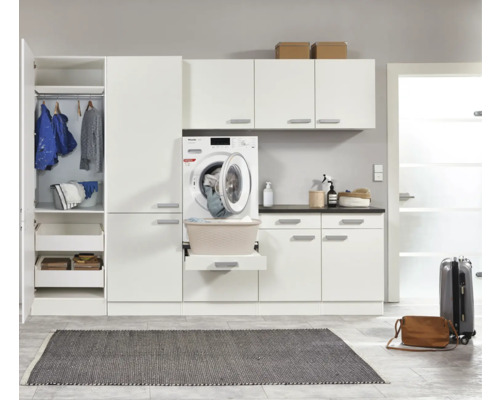 Lichte wasruimte met wasmachine, planken, kasten en wasmand