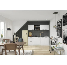 Lichte woonkamer met kitchenette, eettafel en decoraties voor een gezellige sfeer.