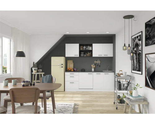 Lichte woonkamer met kitchenette, eettafel en decoraties voor een gezellige sfeer.
