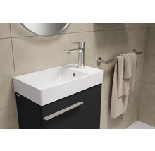 Wastafel met kraan, handdoek en handdoekhouder in de badkamer