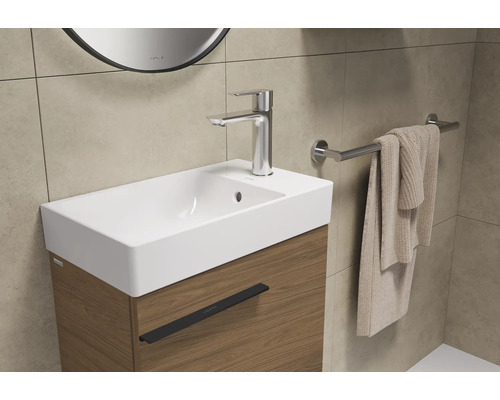 Wastafel met kraan, handdoek en handdoekhouder in de badkamer