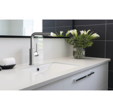 Wastafelmeubel met kraan en witte lelies in vaas