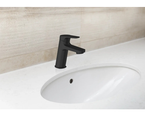 Wastafelkraan in een badkamer met keramische wastafel