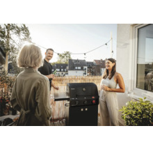 Scène met vrienden die aan het barbecueën zijn op een balkon met een Enders barbecue met zijplanken