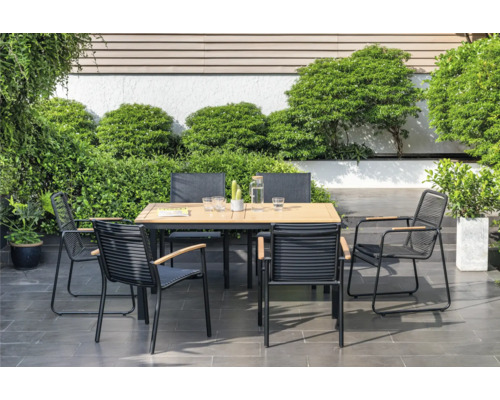 Tuinscene met tuintafel en stoelen op terras, omgeven door planten