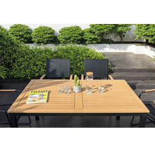 Tuinscene met eettafel, stoelen, glazen, waterkan, tijdschrift en cactus