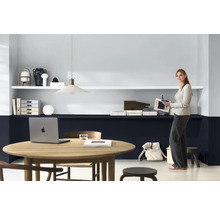 Lichte werkruimte met bureau, planken en een vrouw met een tijdschrift