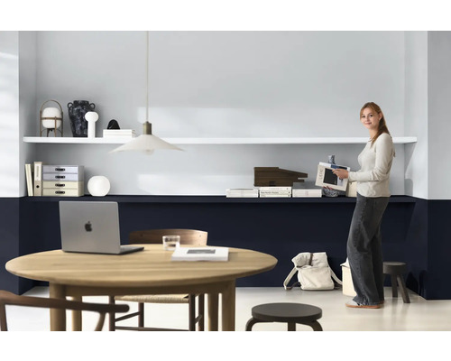 Lichte werkruimte met bureau, planken en een vrouw met een tijdschrift