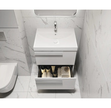 Moderne badkamer met wastafelonderkast, open lade en marmeren tegels