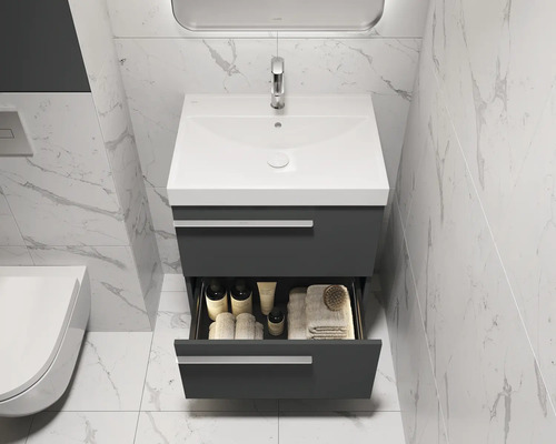 Badkamer met wastafelonderkast, open lade en badkamerartikelen