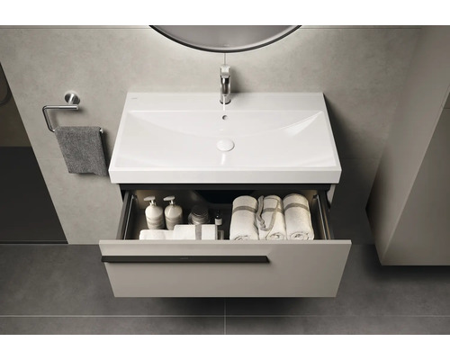 Wastafelonderkast met open lade, voorzien van handdoeken en verzorgingsproducten